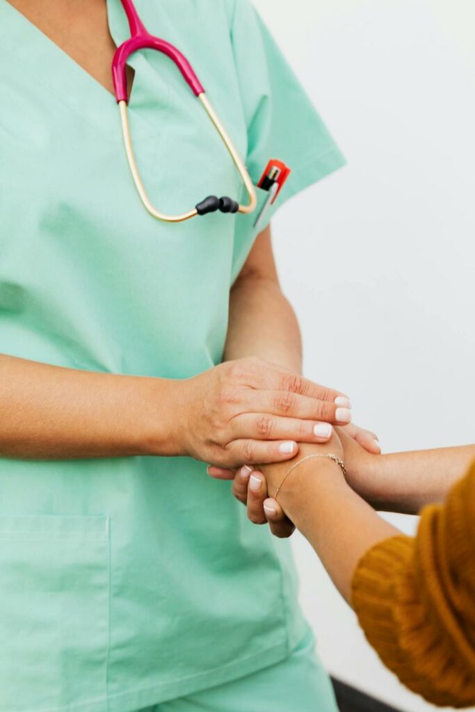 A doctor holding the hands of a patient. 